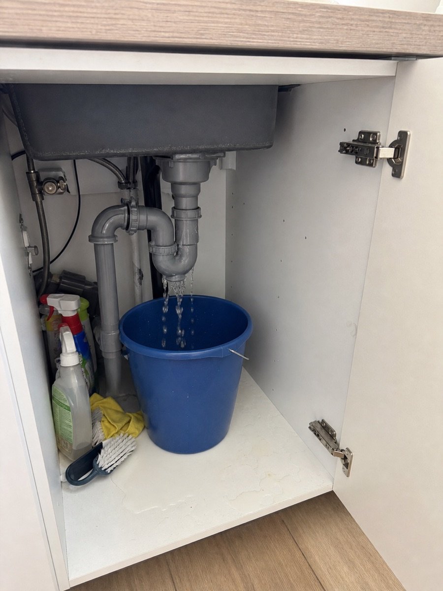Leaking pipe beneath a kitchen sink